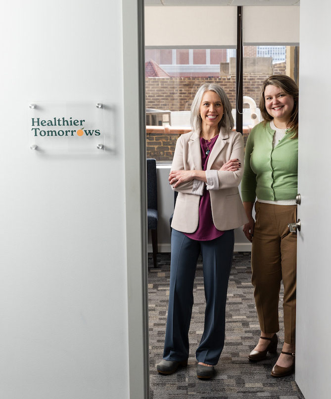 Two women standing in doorway smiling