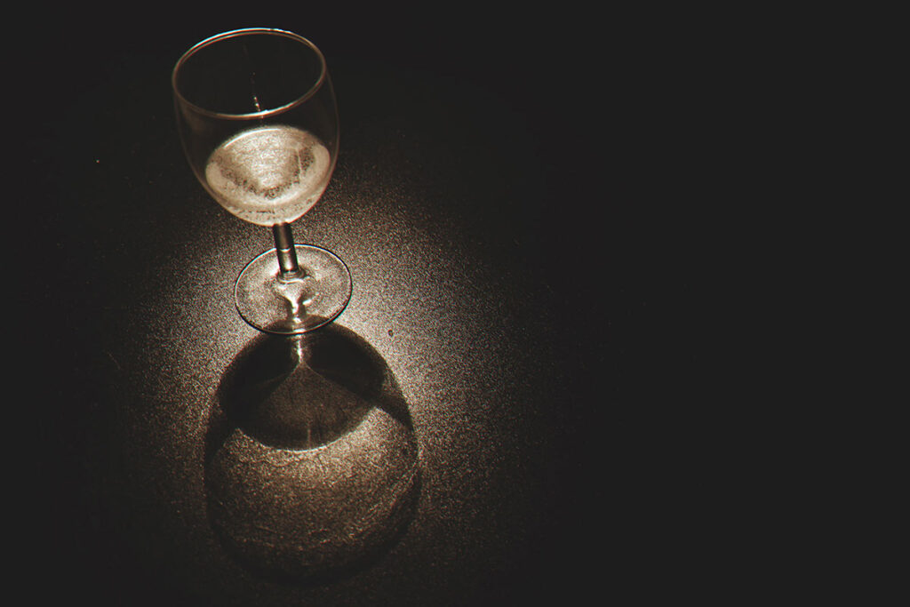 Glass of white wine in dark room