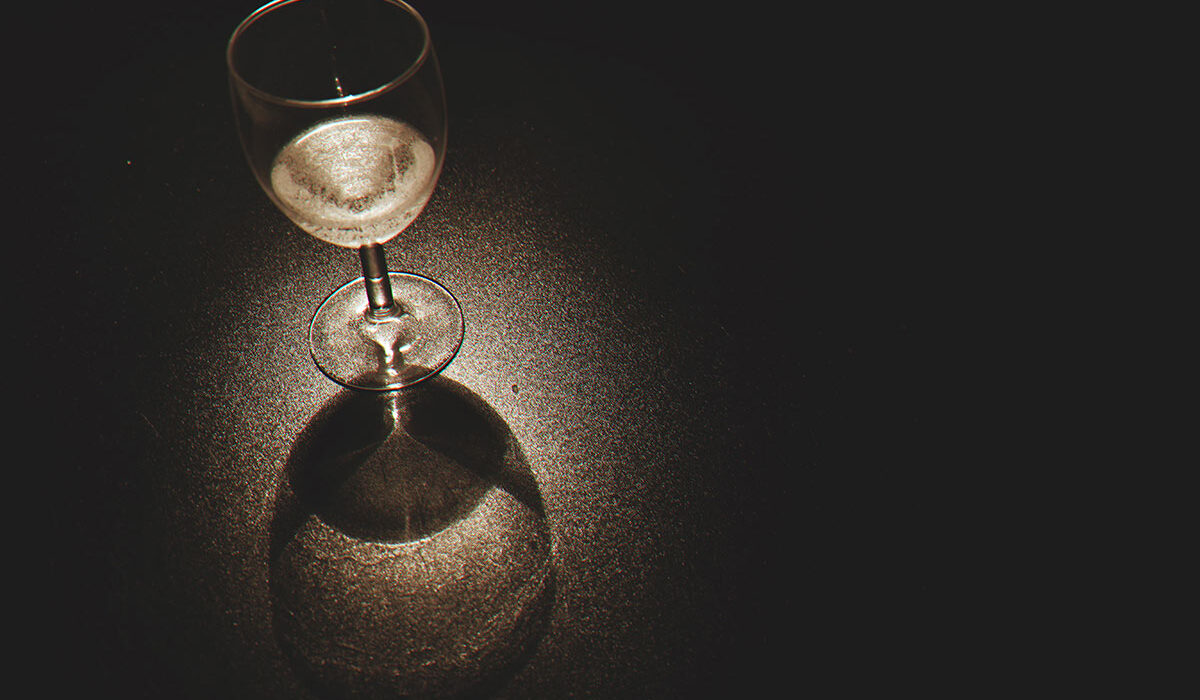 Glass of white wine in dark room