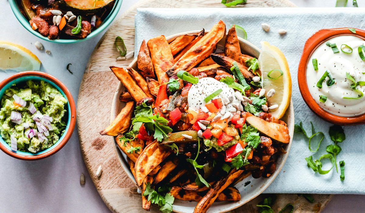 Large plate of pasta with smaller plates of food around it