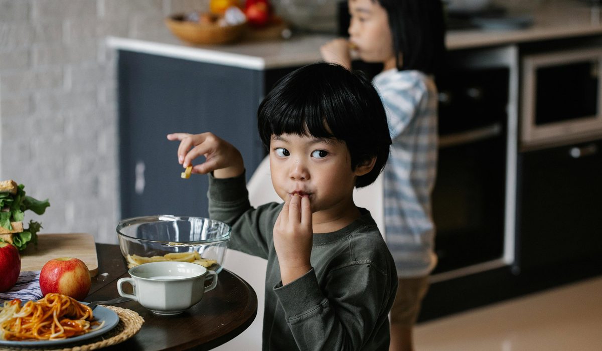 A young child eating meal at table