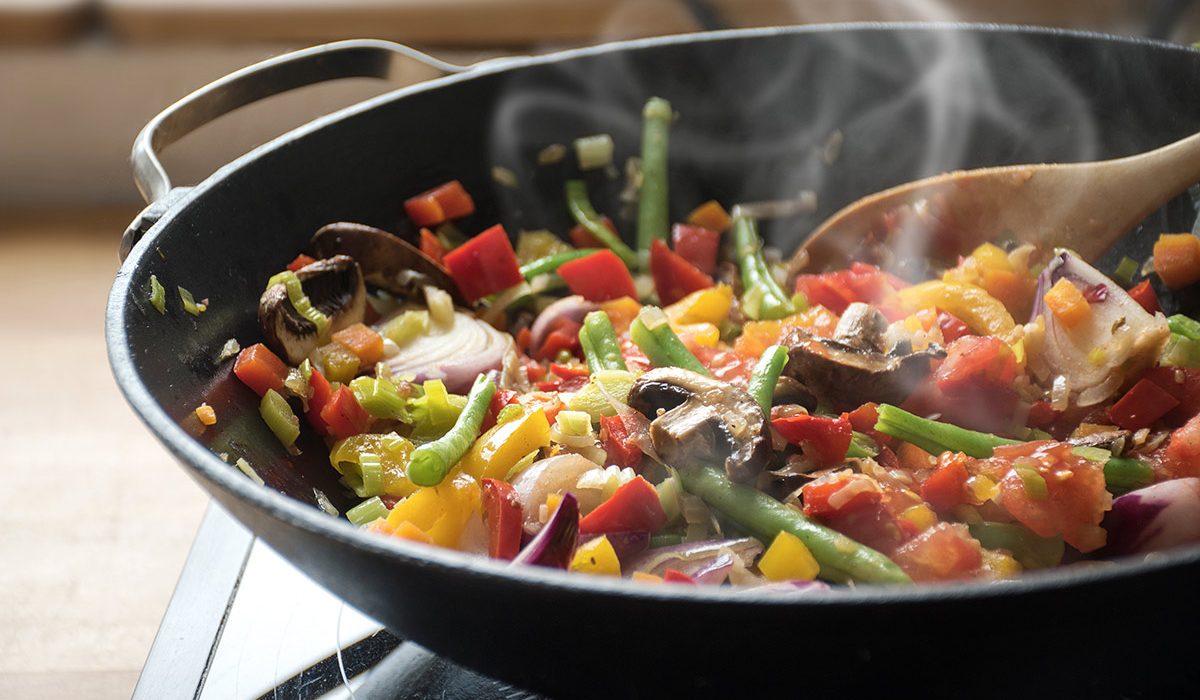 Close Up of Person Stirring Pan of Food