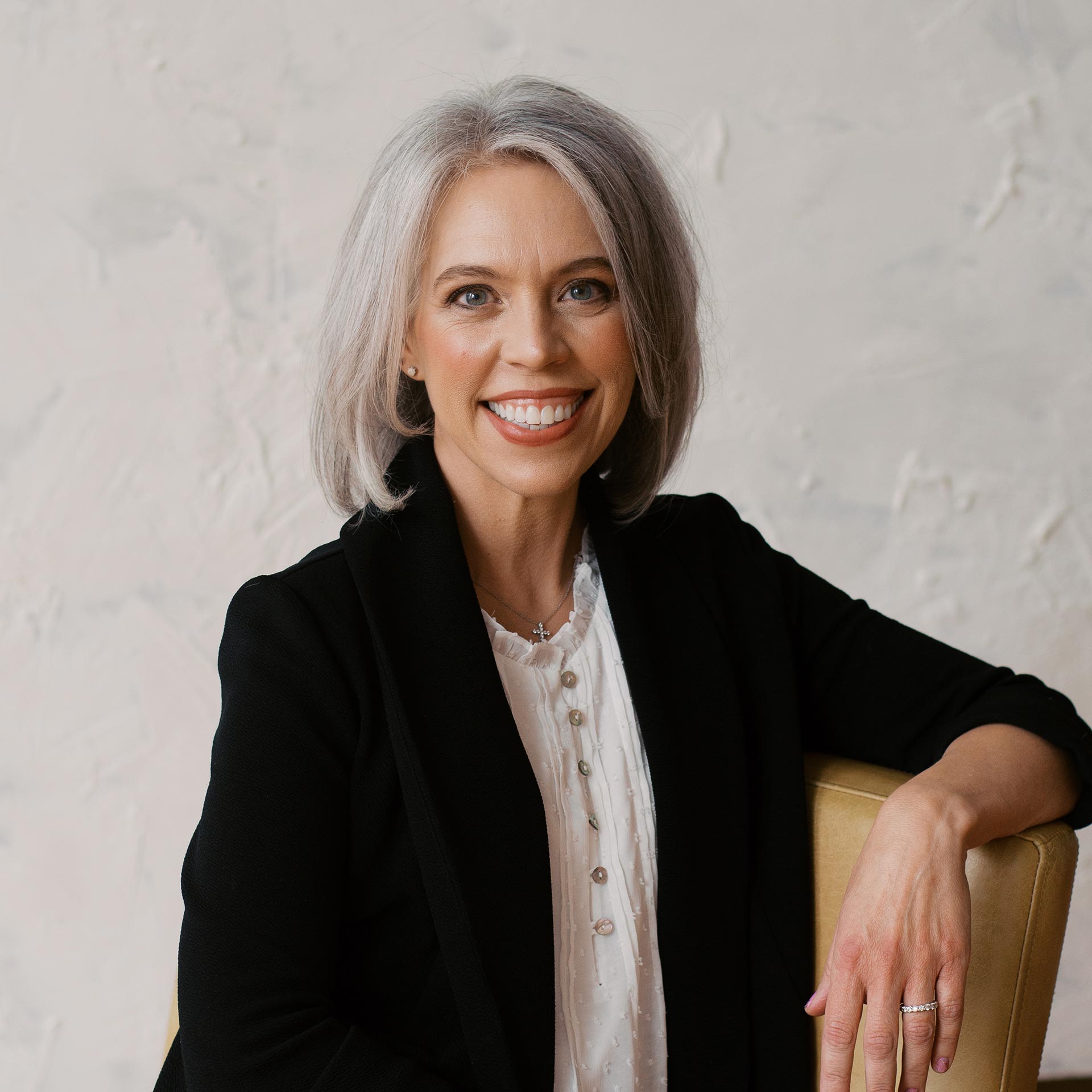 Headshot of Megan Campbell, a white woman with shoulder-length gray hair wearing a white shirt and black blazer.