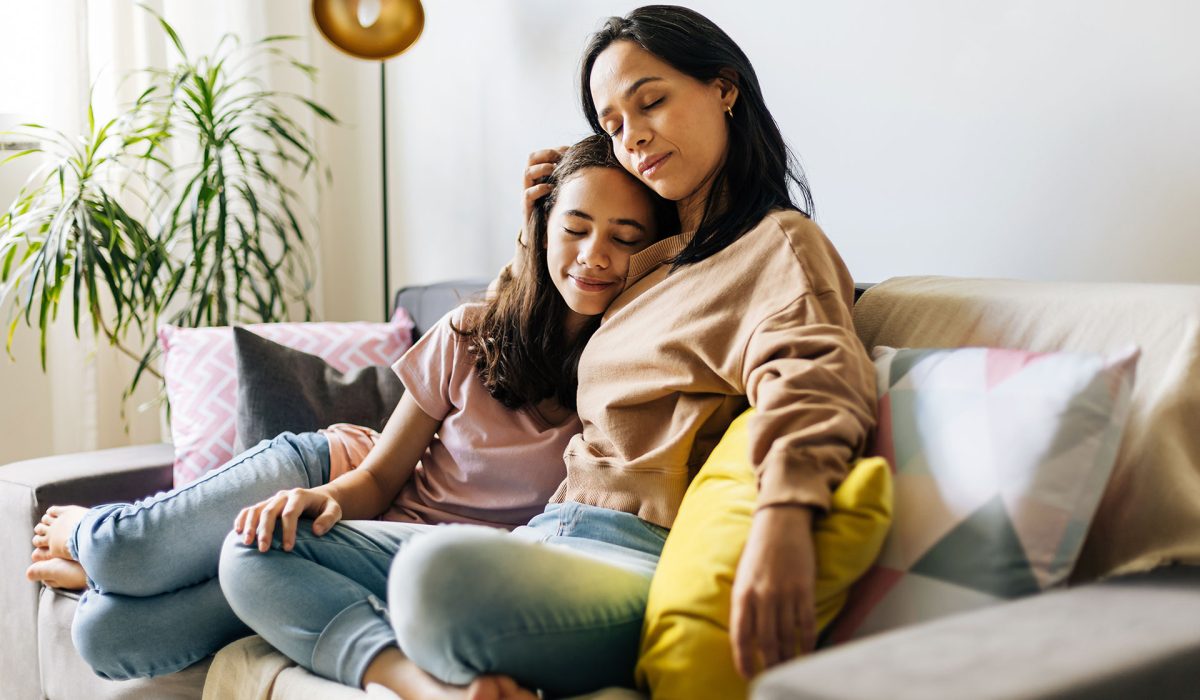 Mother hugging child on couch