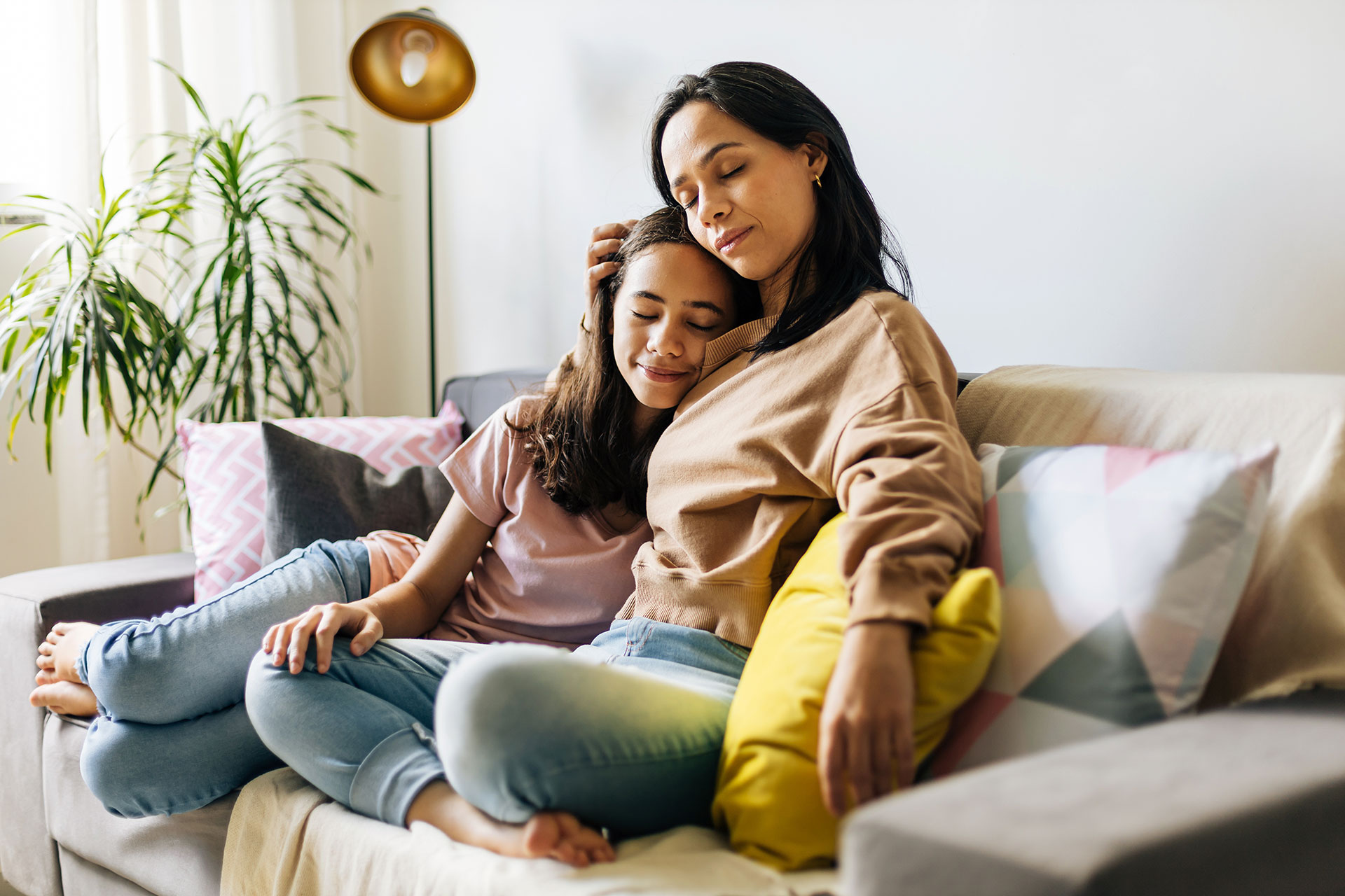 Mother hugging child on couch