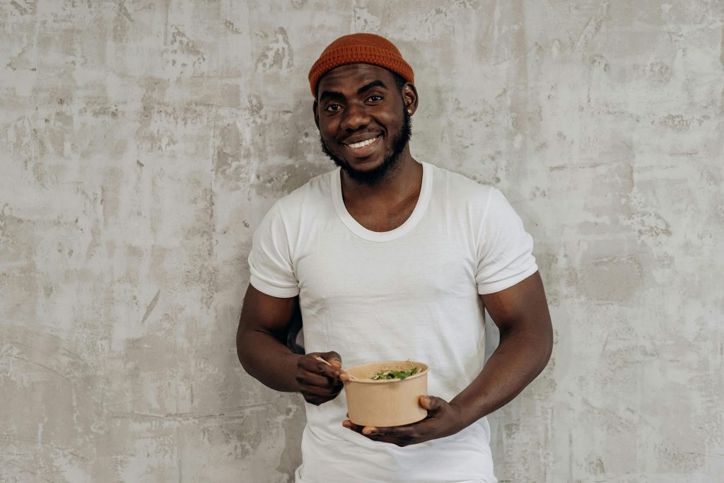 Smiling man enjoying a bowl of nutritious food — the research-based connection between nutrition and mental health