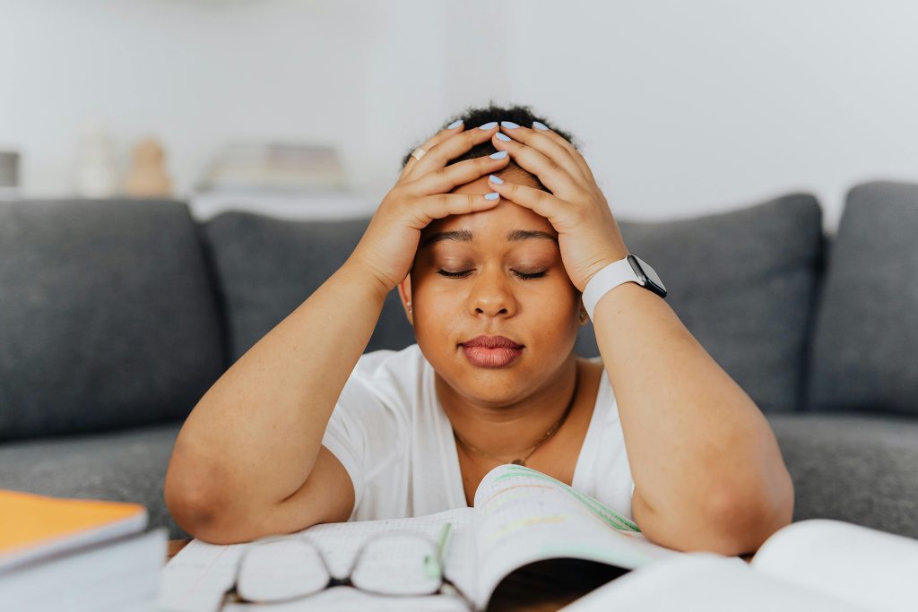Woman sitting on the floor with her head in her hands — supporting nutrition during depression, anxiety, and trauma recovery