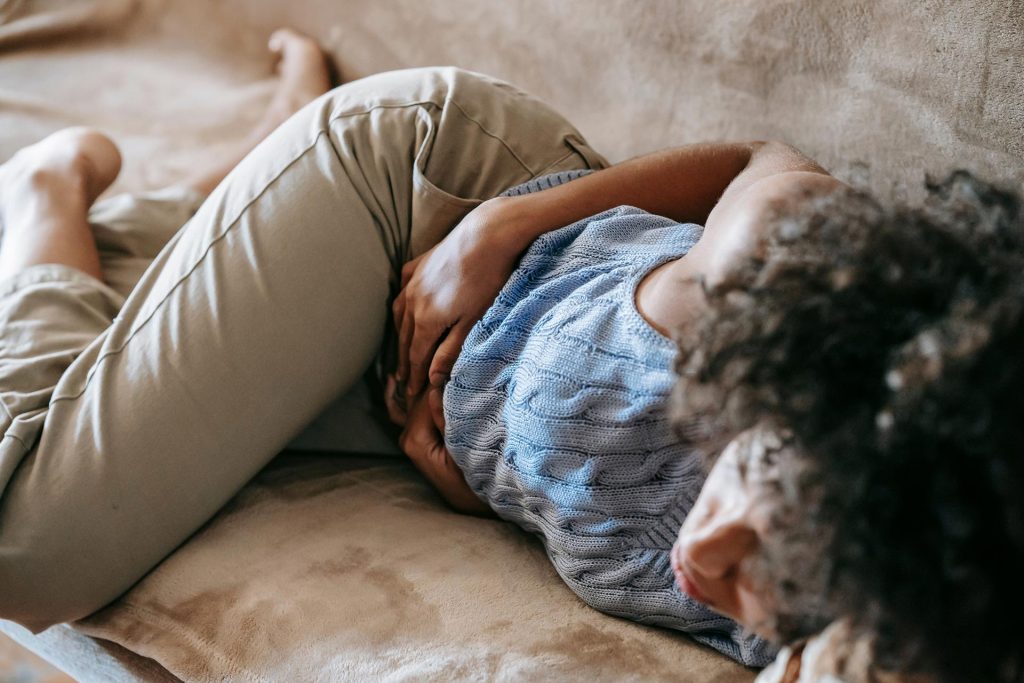 Woman laying on cough holding her stomach